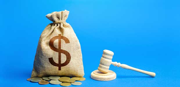 burlap bag with USD sign on it and silver and gold coins below. A gavel sits to the right, with both items against a blue backdrop