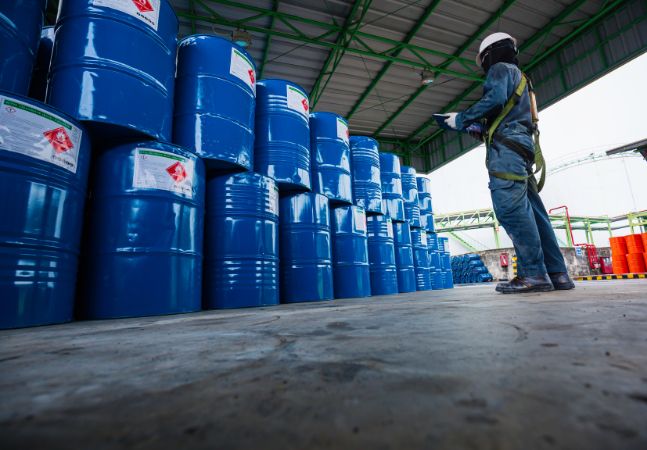 Male worker inspection record drum oil stock barrels blue vertical or chemical