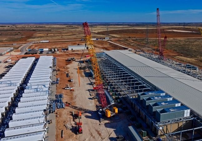 Aerial view of data center construction with BESS batteries and red cranes