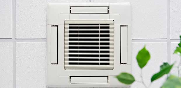 air conditioner on a ceiling with green leaves underneath