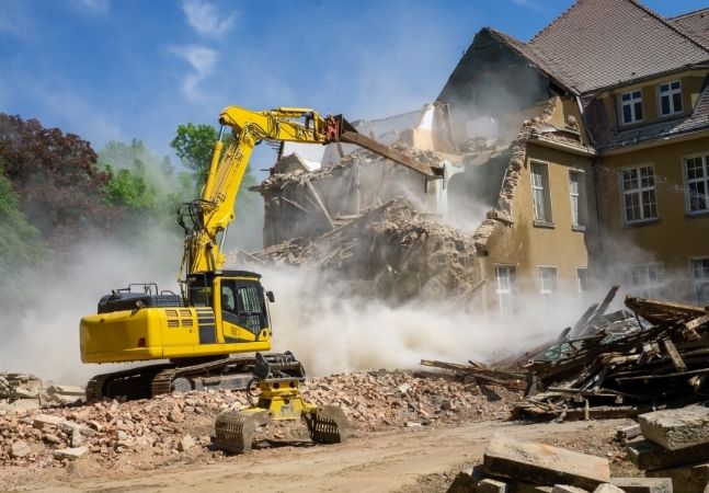 Construction vehicle demolishing house