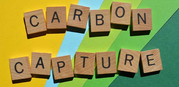 wooden tiles spelling out "carbon capture" against a yellow, blue and green background