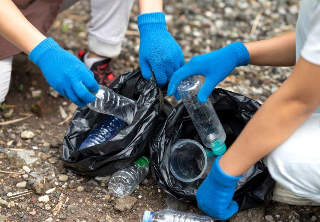 People collecting trash in black bags