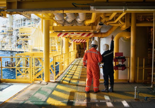 Workers inspecting steel pipes