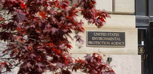 sign on stone building reading "United States Environmental Protection Agency" with a red tree to the left